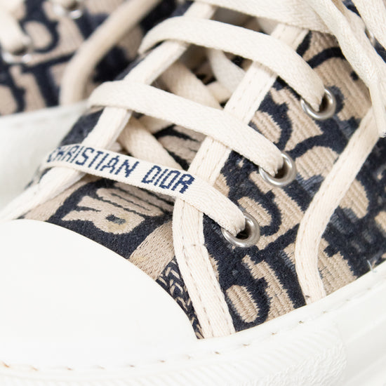 Close-up of white sneakers with Dior logo on a white background