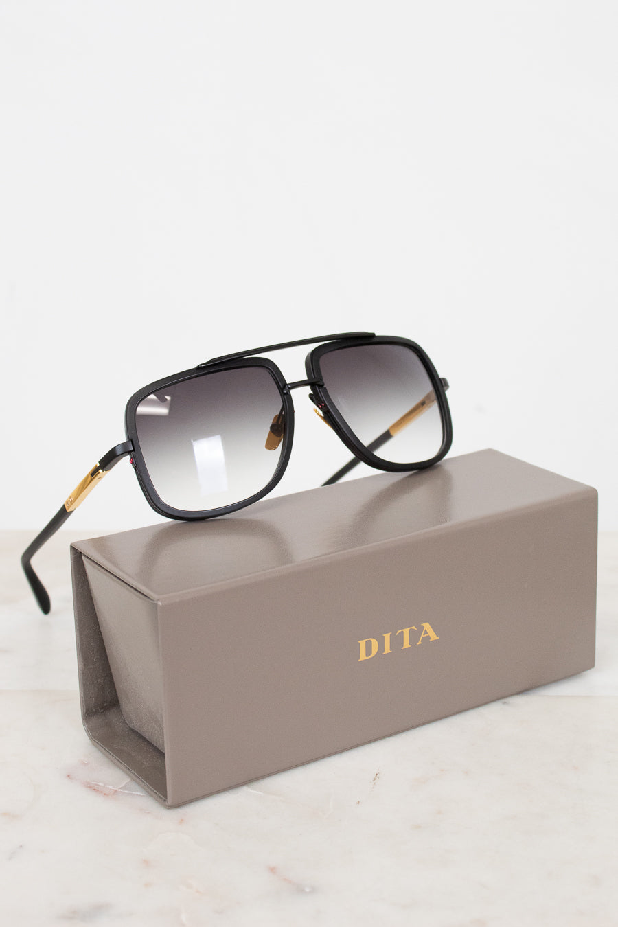 Dita sunglasses on a gray Dita case with a white background