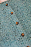 Close-up of a teal knitted garment with button details
