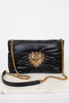 Black handbag with gold chain and heart-shaped embellishment on a white background