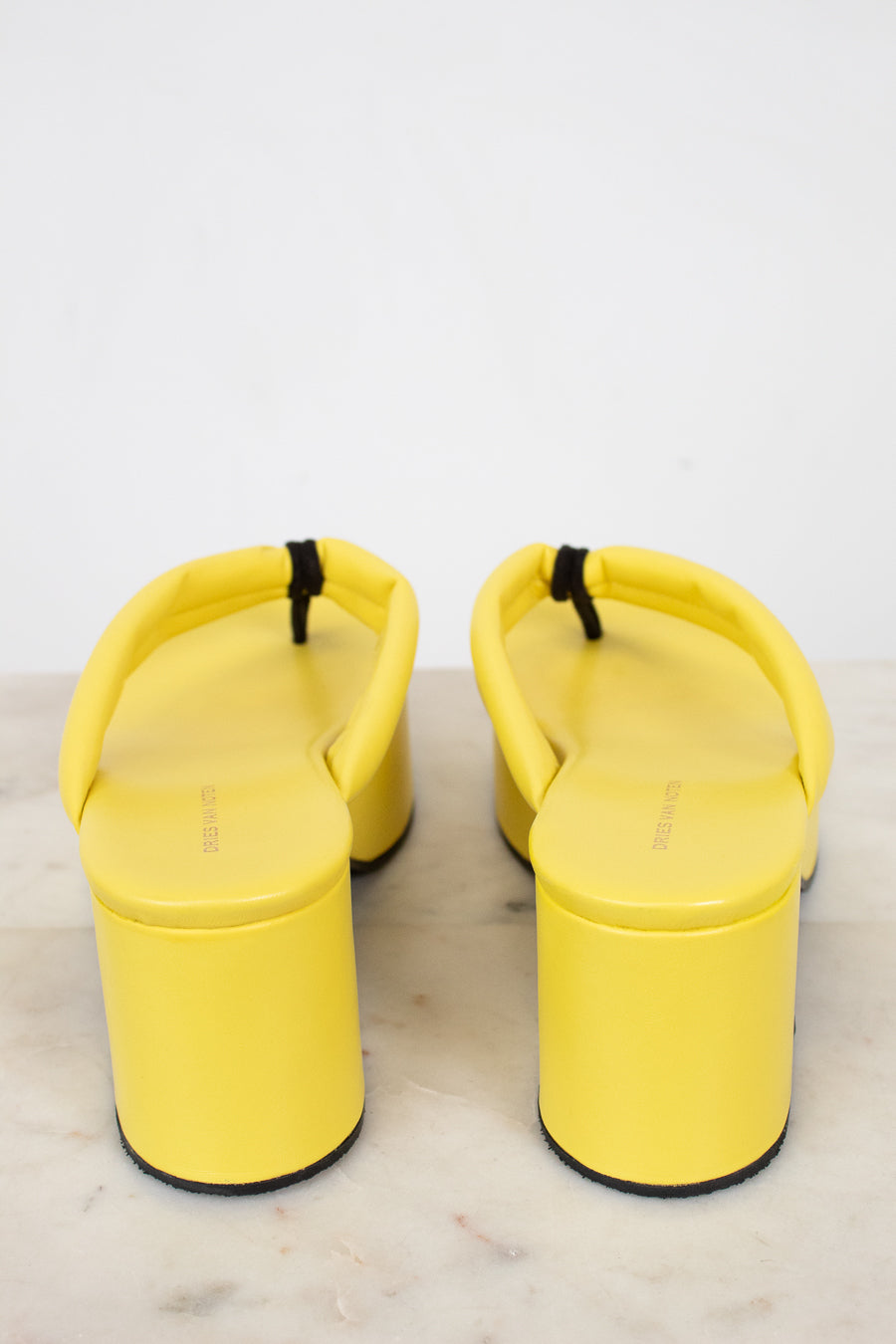 Pair of yellow sandals on a light gray background