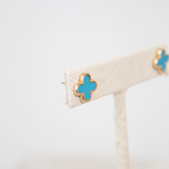 Gold earrings with turquoise and gold accents on a white background