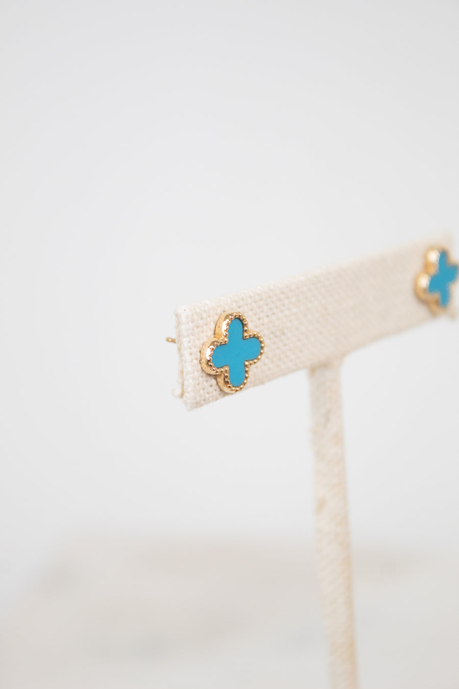 Gold earrings with turquoise and gold accents on a white background