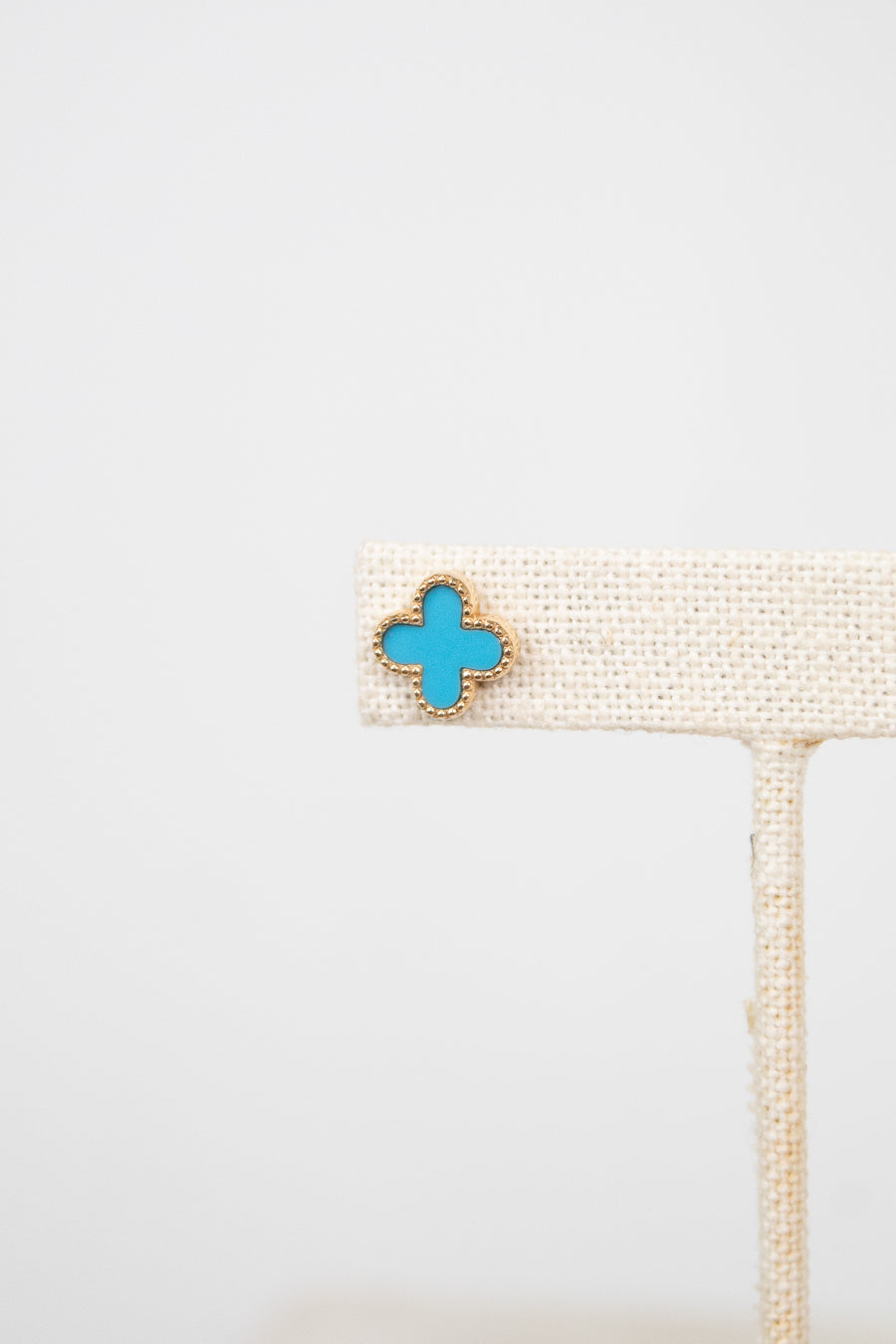 Turquoise floral shaped earring on a white background