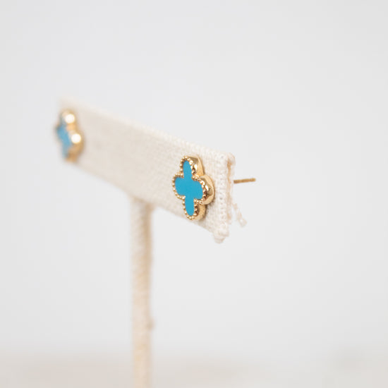 Gold earrings with turquoise stones on a white background