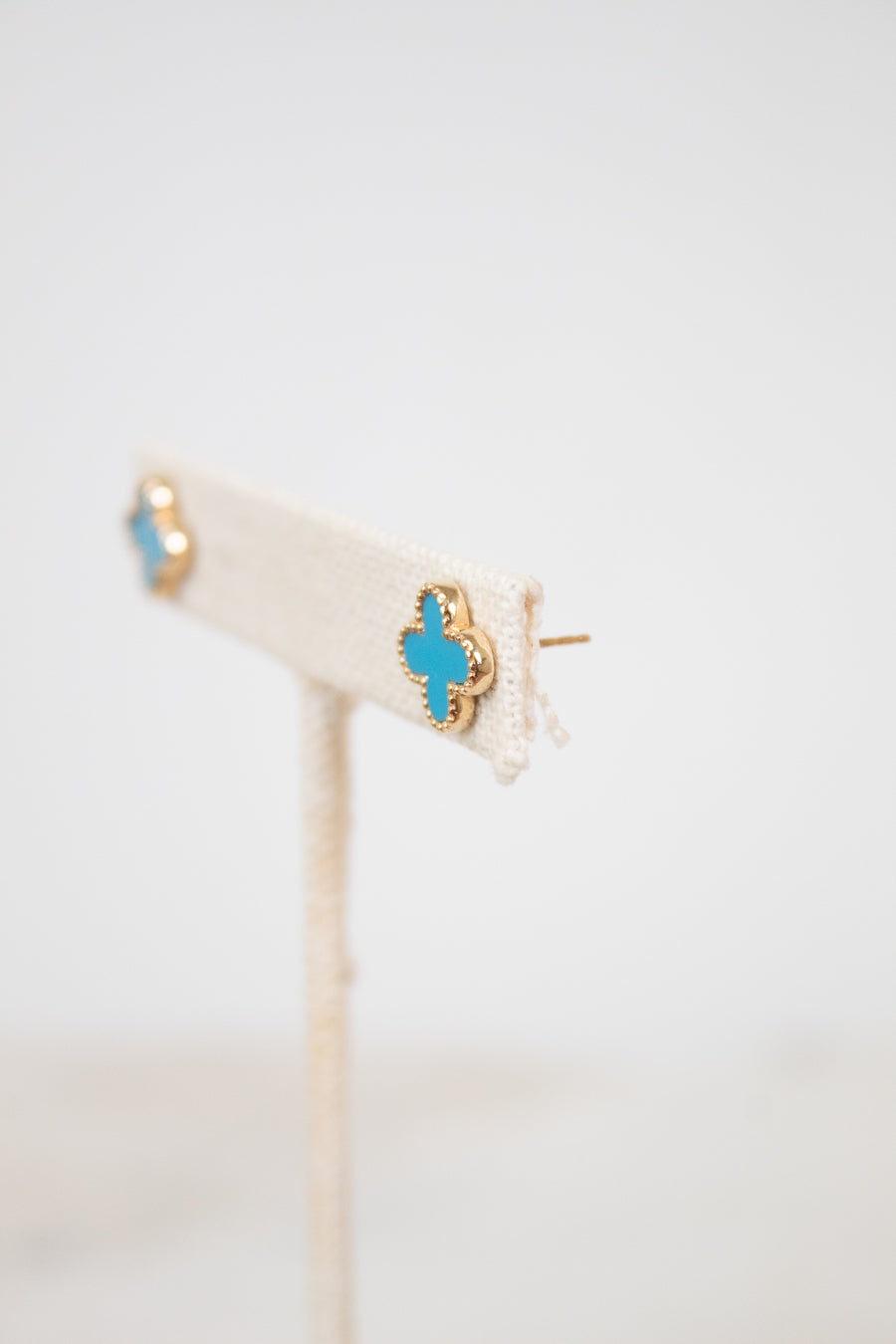 Gold earrings with turquoise stones on a white background