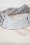 Close-up of 'Fairchild Baldwin Ney York' faded branding stamp on gray leather section displayed on top of a marble slab