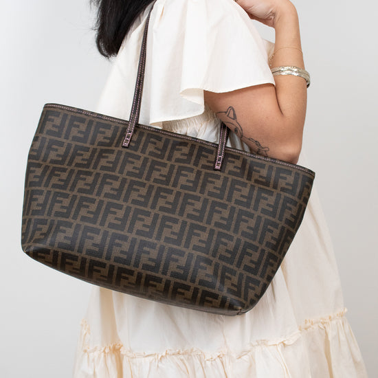 Model carrying Fendi handbag with a prominent FF logo on a white background