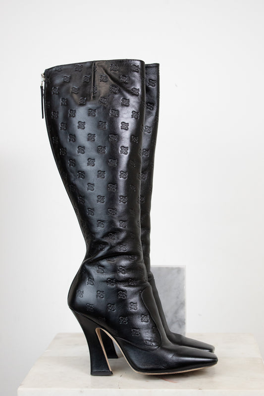 Black knee-high boots with a pattern on a white background