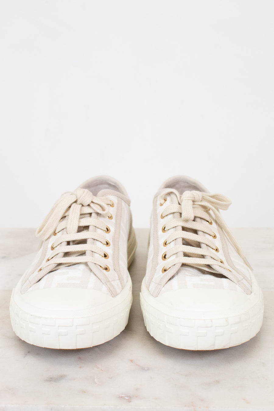 Pair of white sneakers on a light gray background
