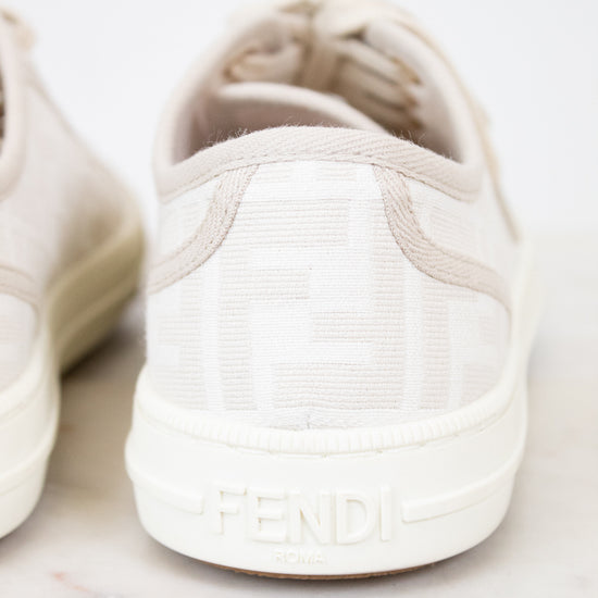 White Fendi sneakers on a light marble background