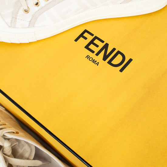 White sneakers with yellow Fendi box on a white background