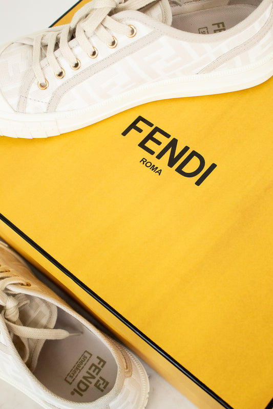 White sneakers with yellow Fendi box on a white background