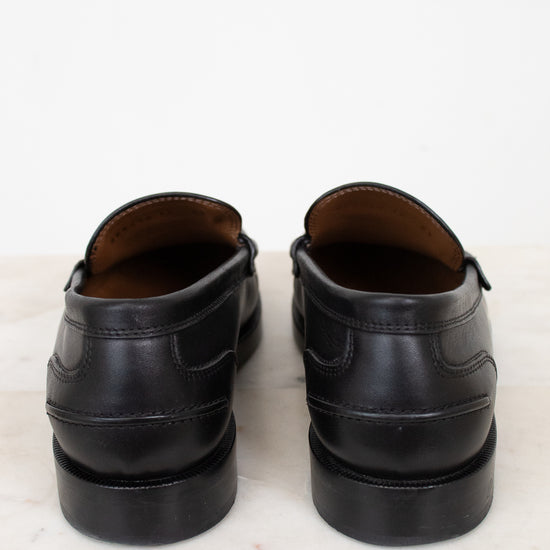 Pair of black leather shoes on a light marble surface