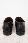 Pair of black leather shoes on a light marble surface