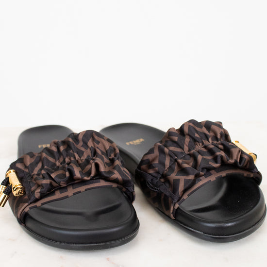 Pair of black slides with Zucca print straps on a white background