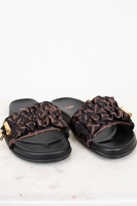 Pair of black slides with Zucca print straps on a white background