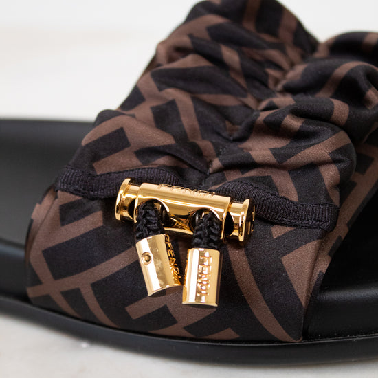 Brown patterned sandal with gold clasp on a white background