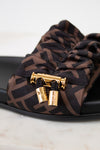 Brown patterned sandal with gold clasp on a white background