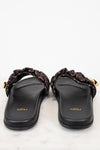 Pair of black sandals with gold accents on a white background