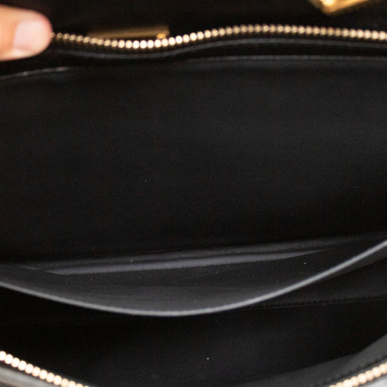 Close-up of a black handbag with a gold zipper
