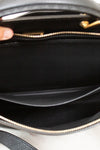 Close-up of a black handbag with a gold zipper