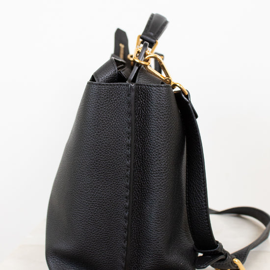 Black leather handbag with gold zipper on a white background