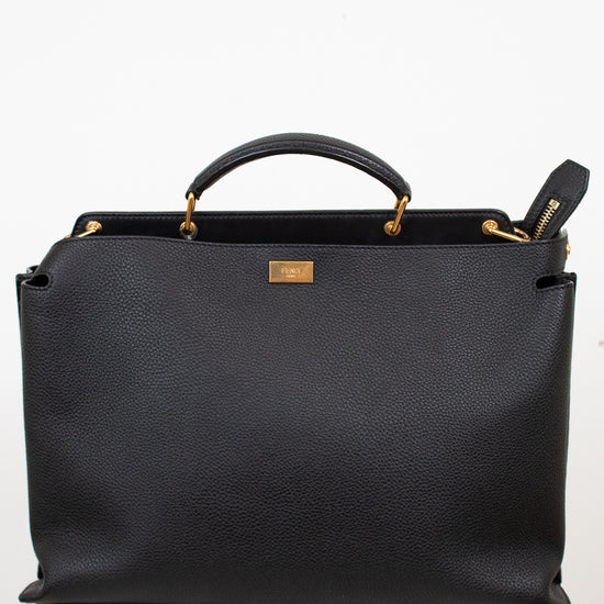 Black leather handbag with gold accents on a white background