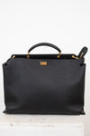 Black leather handbag with gold accents on a white background