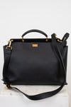 Black leather handbag with gold accents on a white background