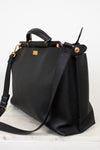 Black leather handbag with gold accents on a white background