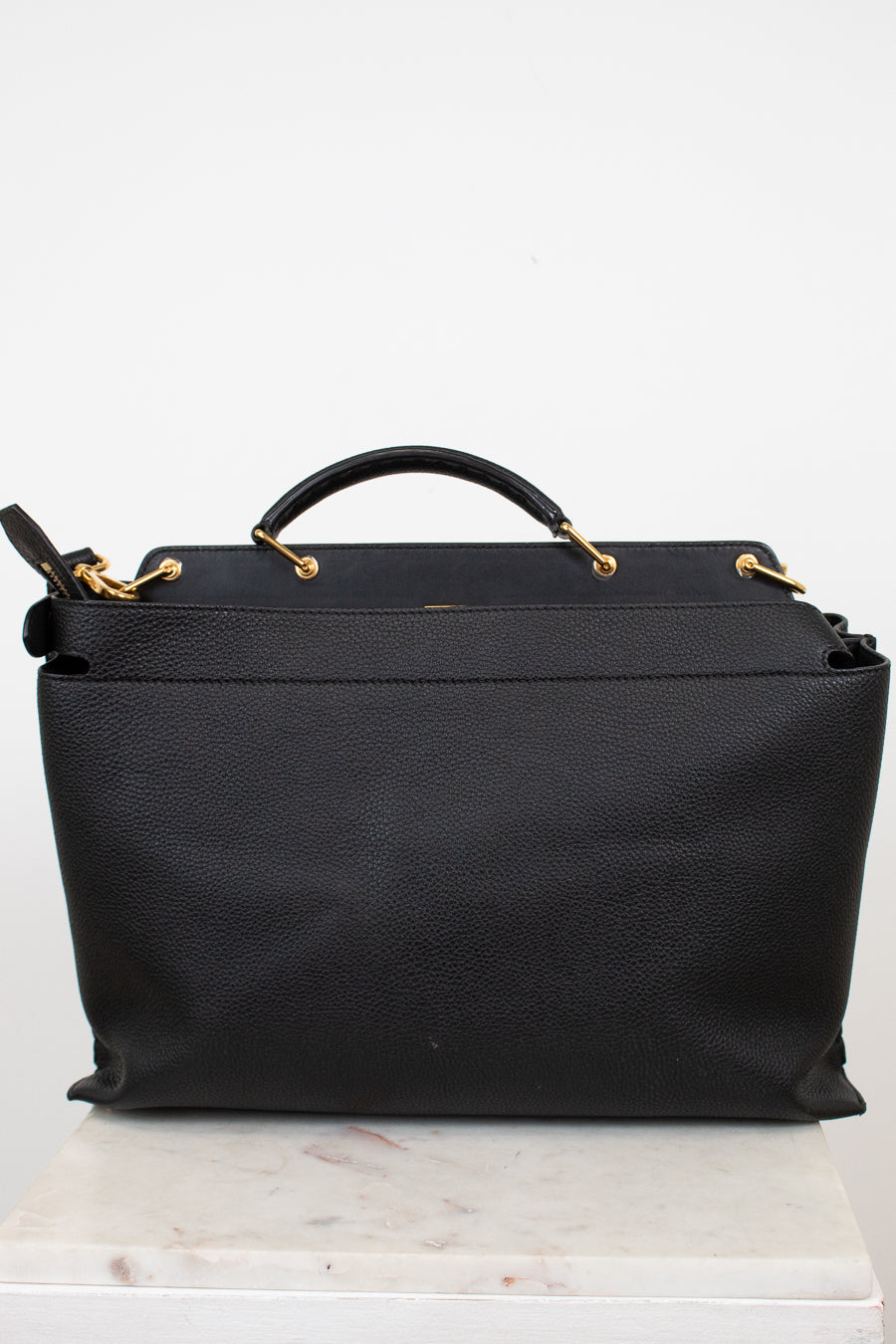 Black handbag with gold accents on a white background