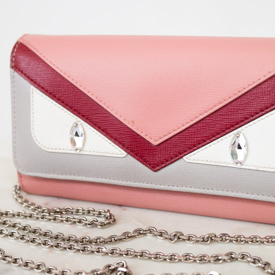 Pink and white handbag with a chain detail on a light background