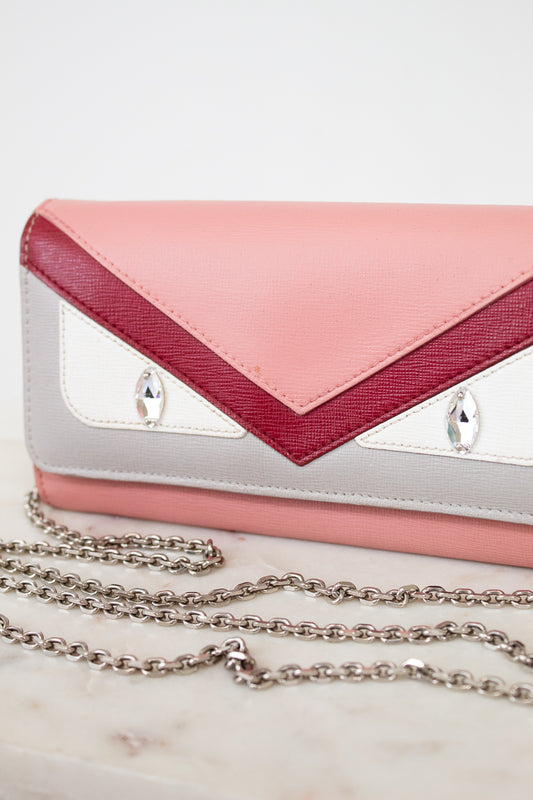 Pink and white handbag with a chain detail on a light background