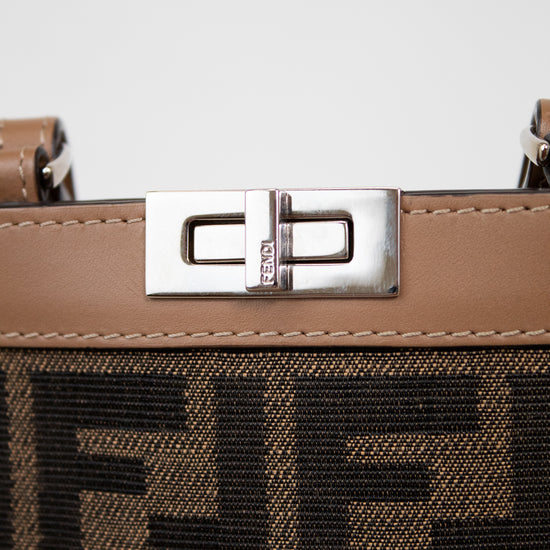 Close-up of a brown phone holder with a silver clasp and decorative logos on a light gray background
