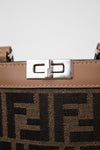 Close-up of a brown phone holder with a silver clasp and decorative logos on a light gray background