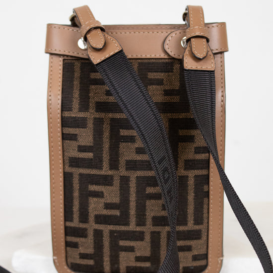 Brown crossbody phone holder with black strap on a white background
