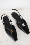 A pair of black leather pointed-toe slingback flats with gold-tone Fendi FF logo hardware, displayed on a light marble surface.
