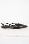 A black leather pointed-toe flat sandal with a slingback strap and a small gold-tone metal detail, displayed on a light marble surface against a white background.