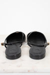 A pair of black Fendi slingback flat sandals with gold-tone buckle details, shown from the back on a white marble surface against a white background.