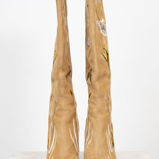 Tan boots with floral embroidery on a white background