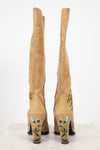 Tan knee-high boots with floral embroidery on a white background