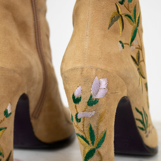 Tan boots with floral embroidery on a white background