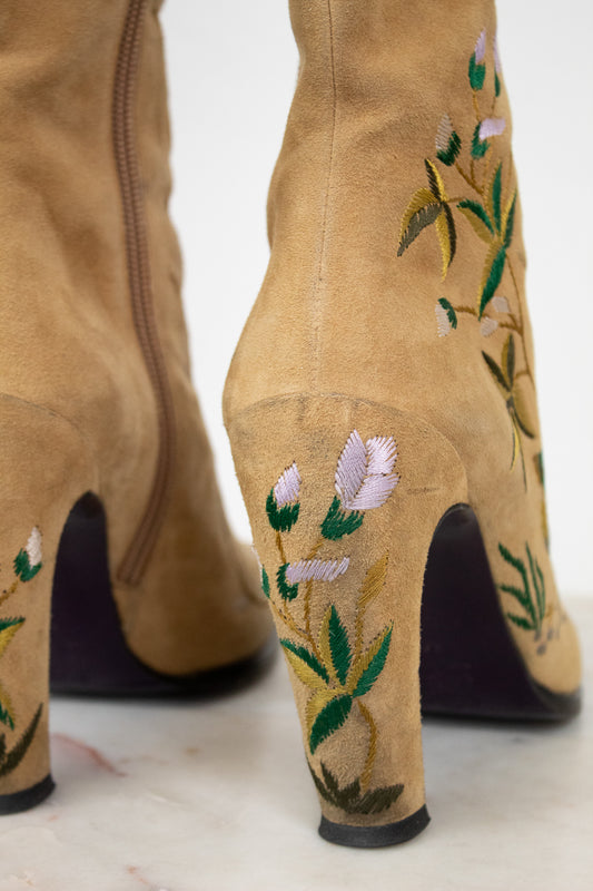 Tan boots with floral embroidery on a white background