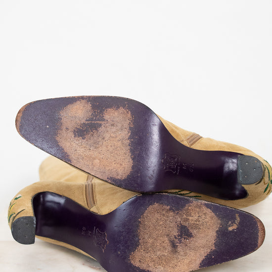Pair of worn shoes with dark soles on a light background