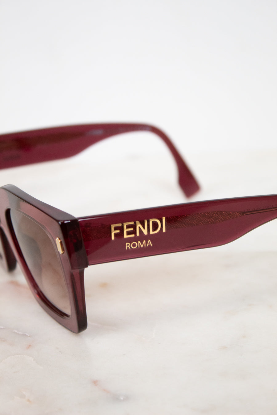 Fendi sunglasses with gold logo on a light background