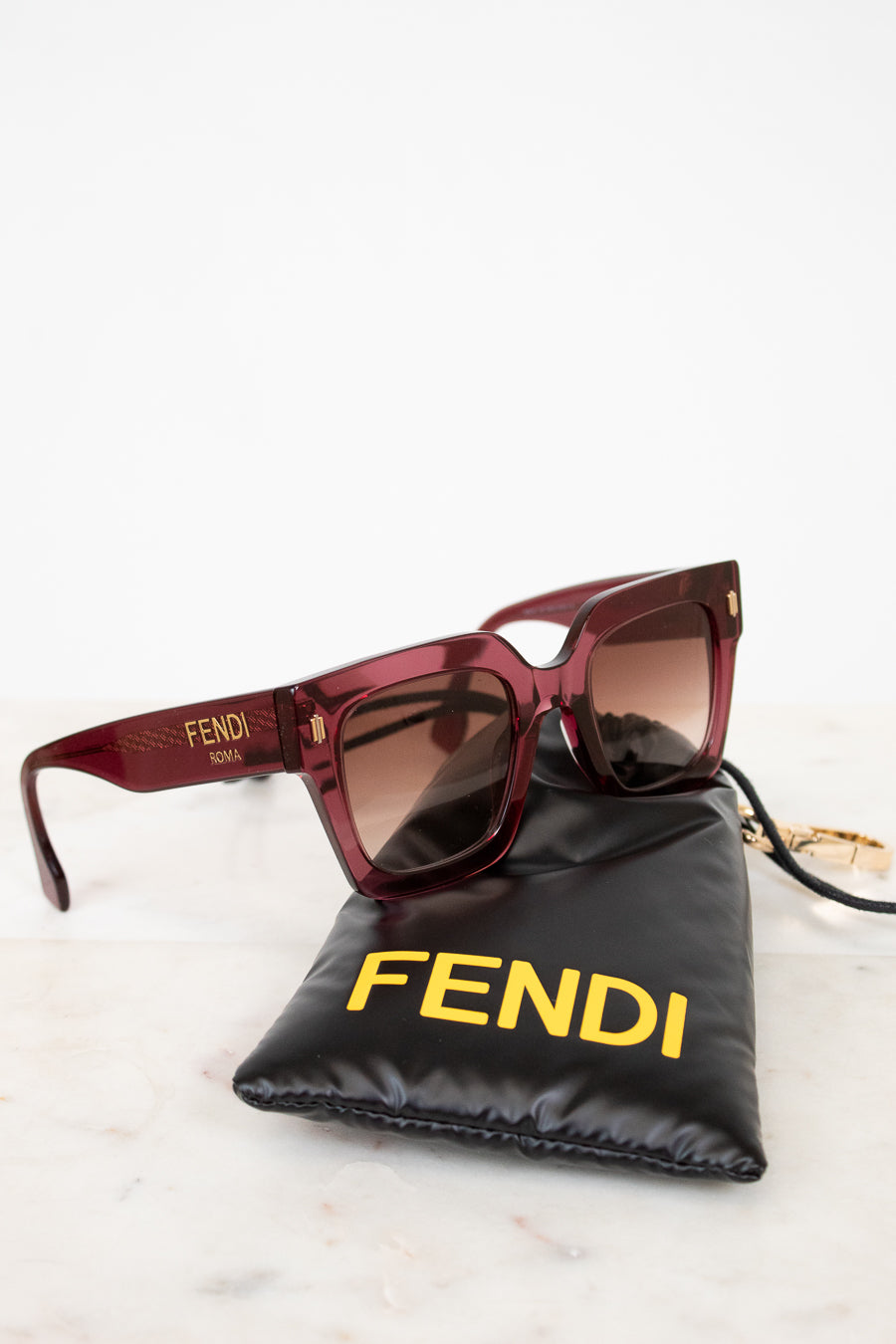 Fendi sunglasses with a black pouch on a white background