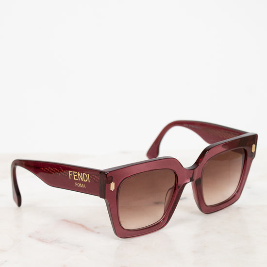 Purple tinted sunglasses with a brand logo on a light background