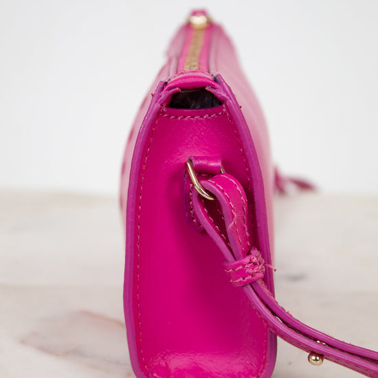 Pink handbag with a strap on a light marble background