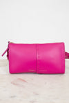Pink crossbody bag with Frame/Les Second brand name on a light marble background